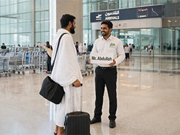 Driver welcoming a pilgrim at airport arrivals
